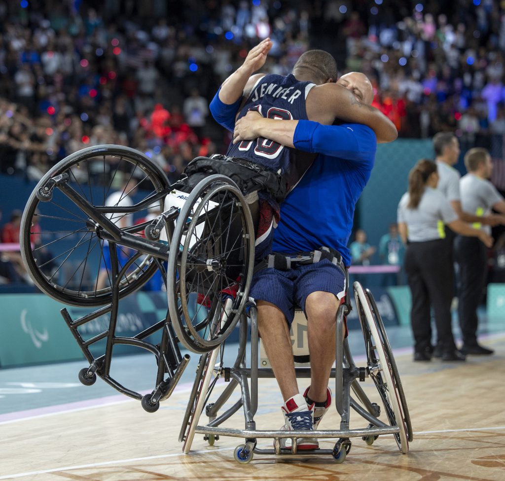 Two wheelchair basketball athletes embrace / Deux athlètes de basket-ball en fauteuil roulant s'embrassent